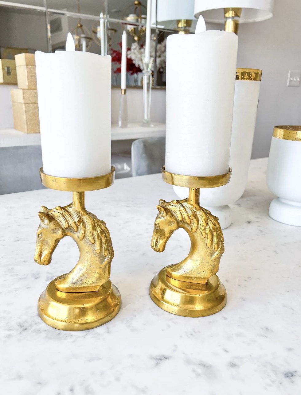 Brass horse-head candlesticks on a marble counter